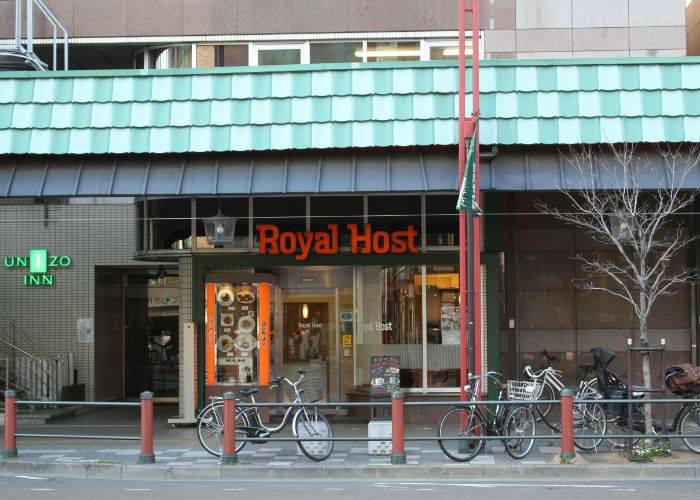 The exterior of a Royal Host, a family restaurant chain in Japan. Bicycles are parked outside.